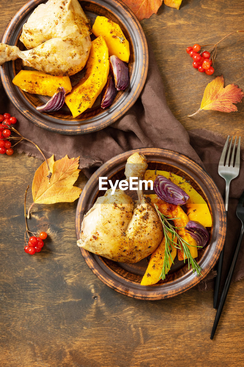 Homemade thanksgiving dinner ripe pumpkin and thanksgiving turkey on a dark wooden table.  