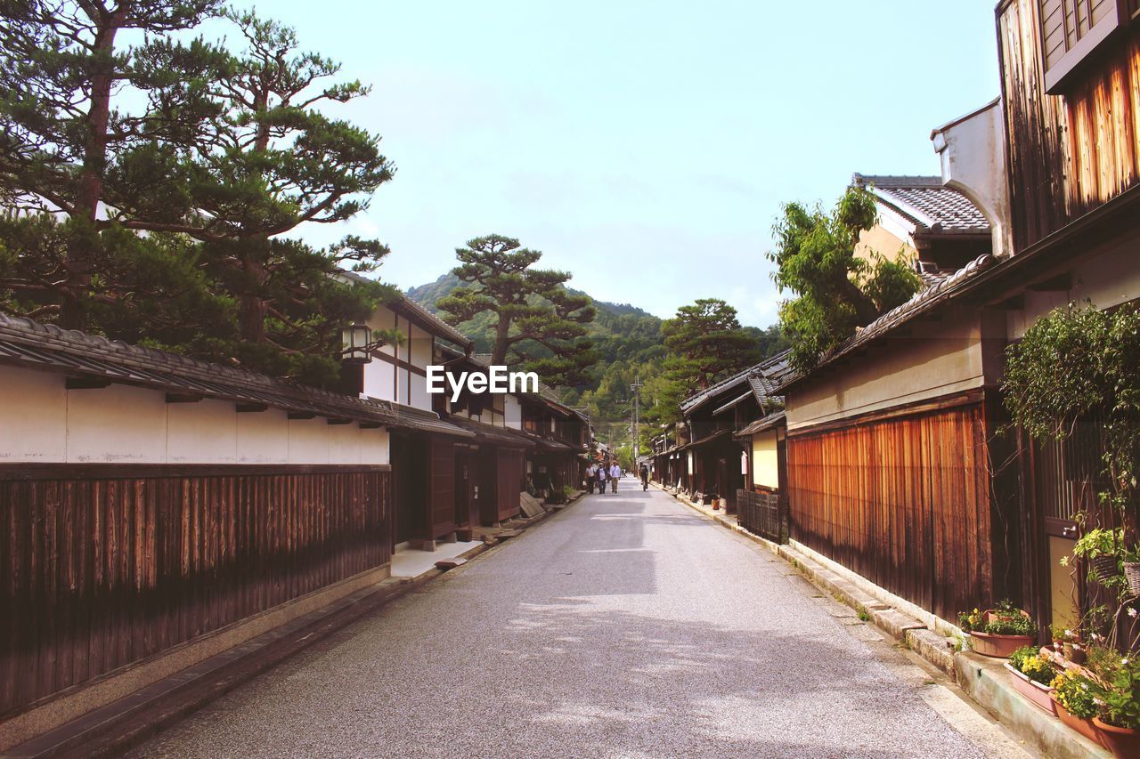 Empty road amidst buildings against clear sky