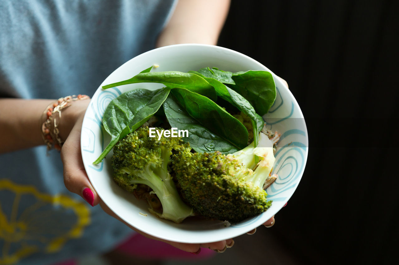 Close-up of woman holding fresh salad in bowl