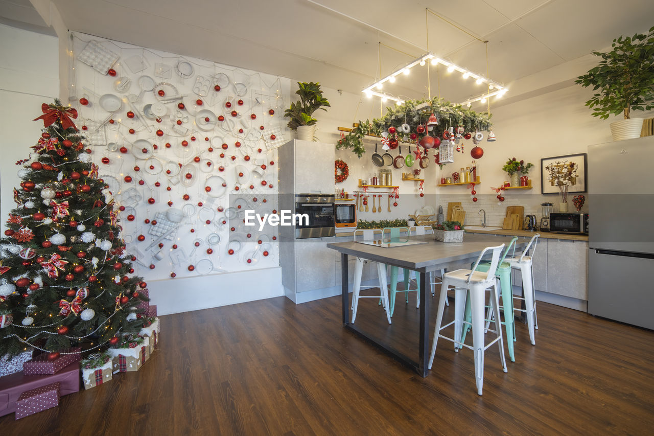 Interior of a cozy modern spacious kitchen for a large family, decorated for new year celebration