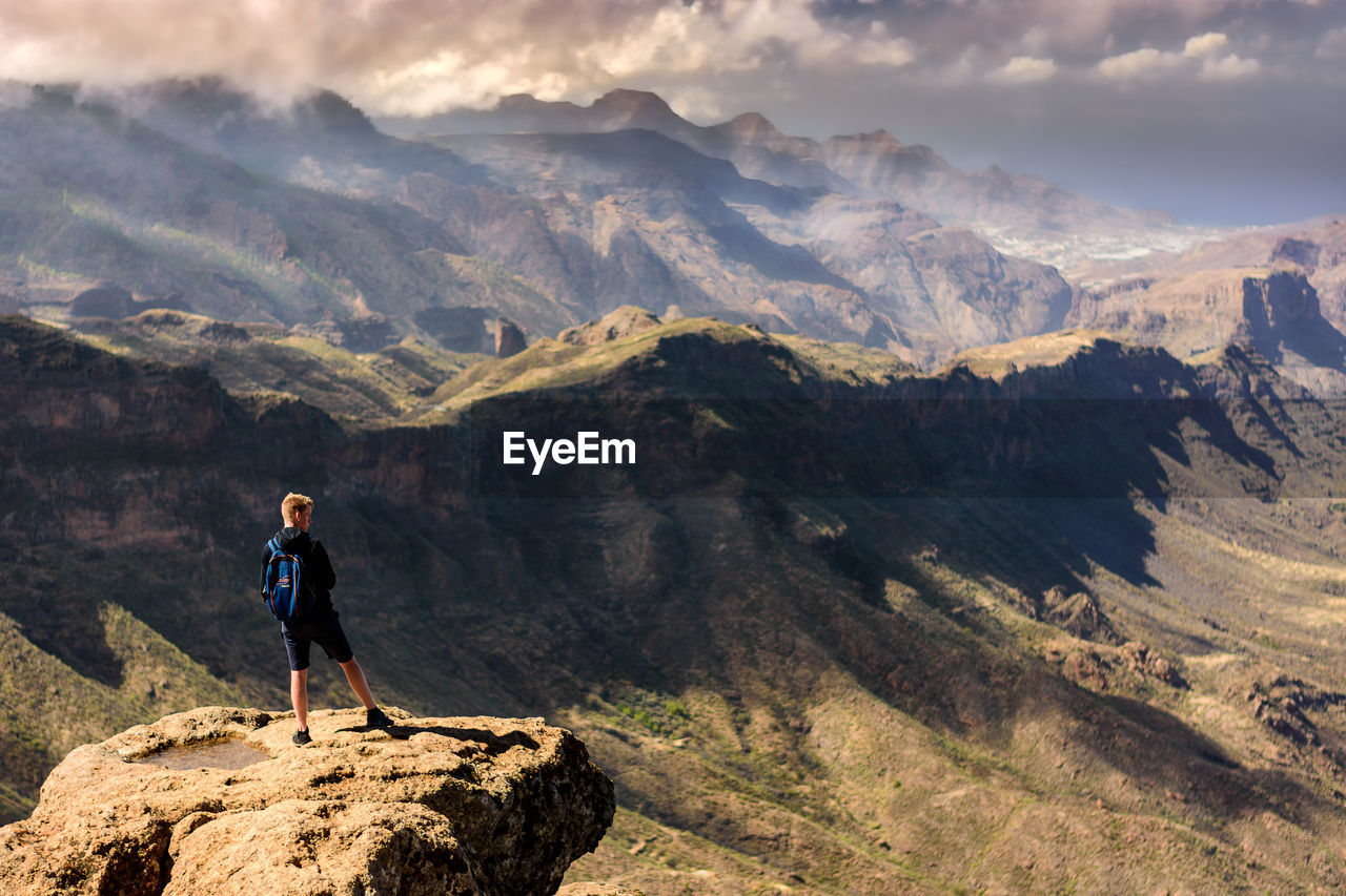 Rear view of man standing on cliff