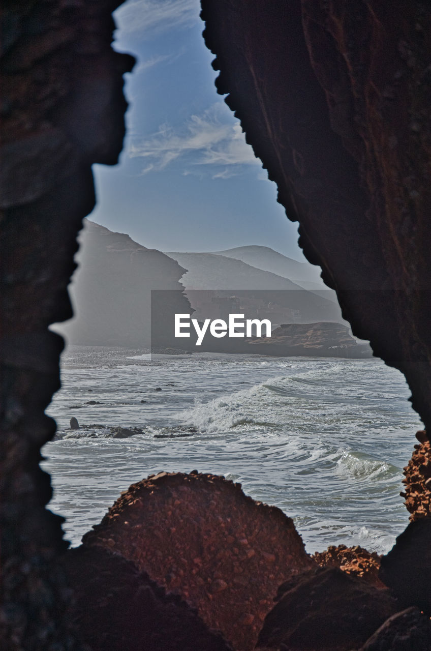 ROCK FORMATIONS ON BEACH AGAINST SKY