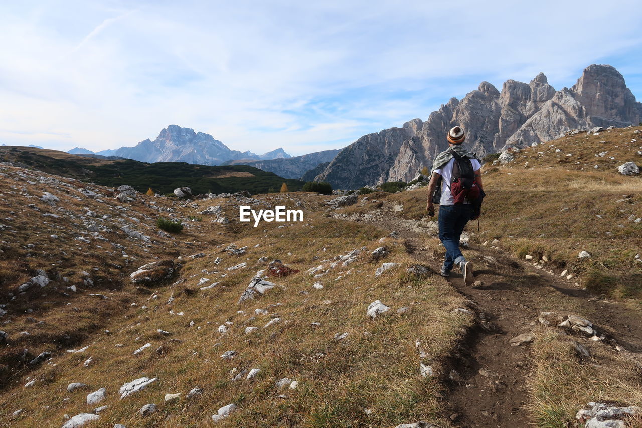 Rear view of hiker walking on mountain