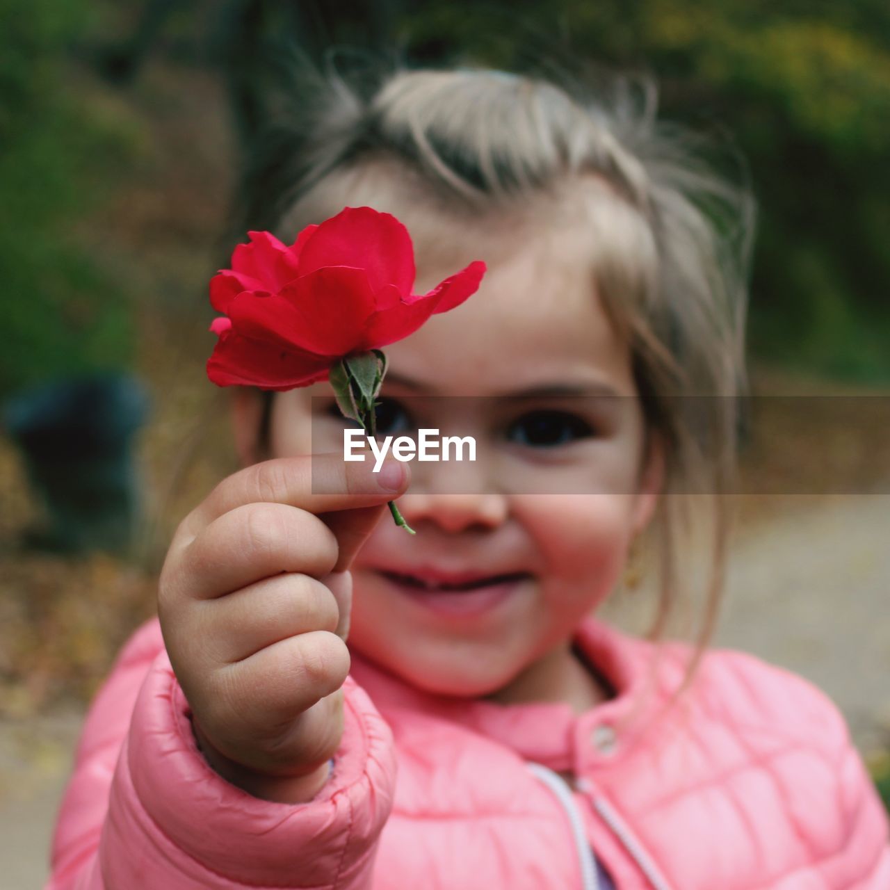 Close-up portrait of girl holding red flower