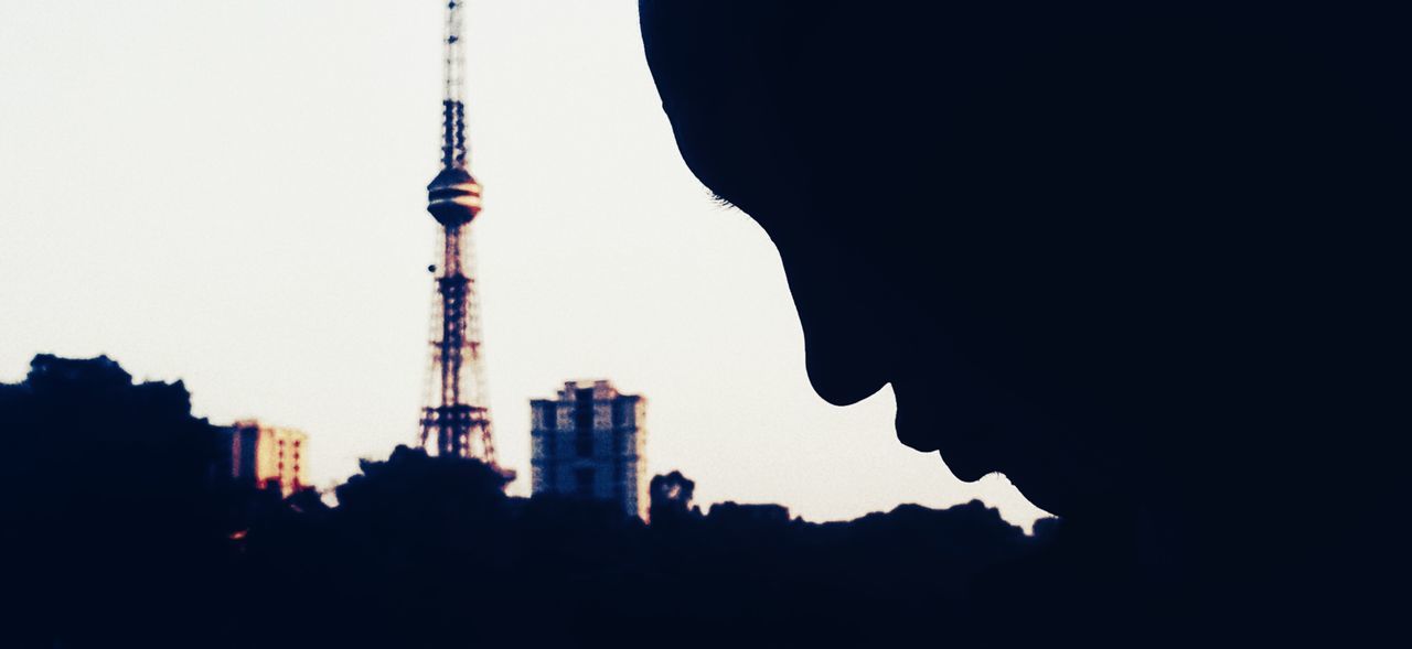 LOW ANGLE VIEW OF COMMUNICATIONS TOWER IN CITY