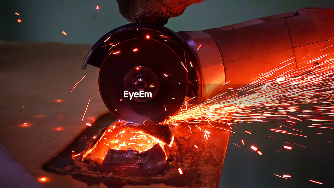 Close-up of sparks emitting from electric saw in factory