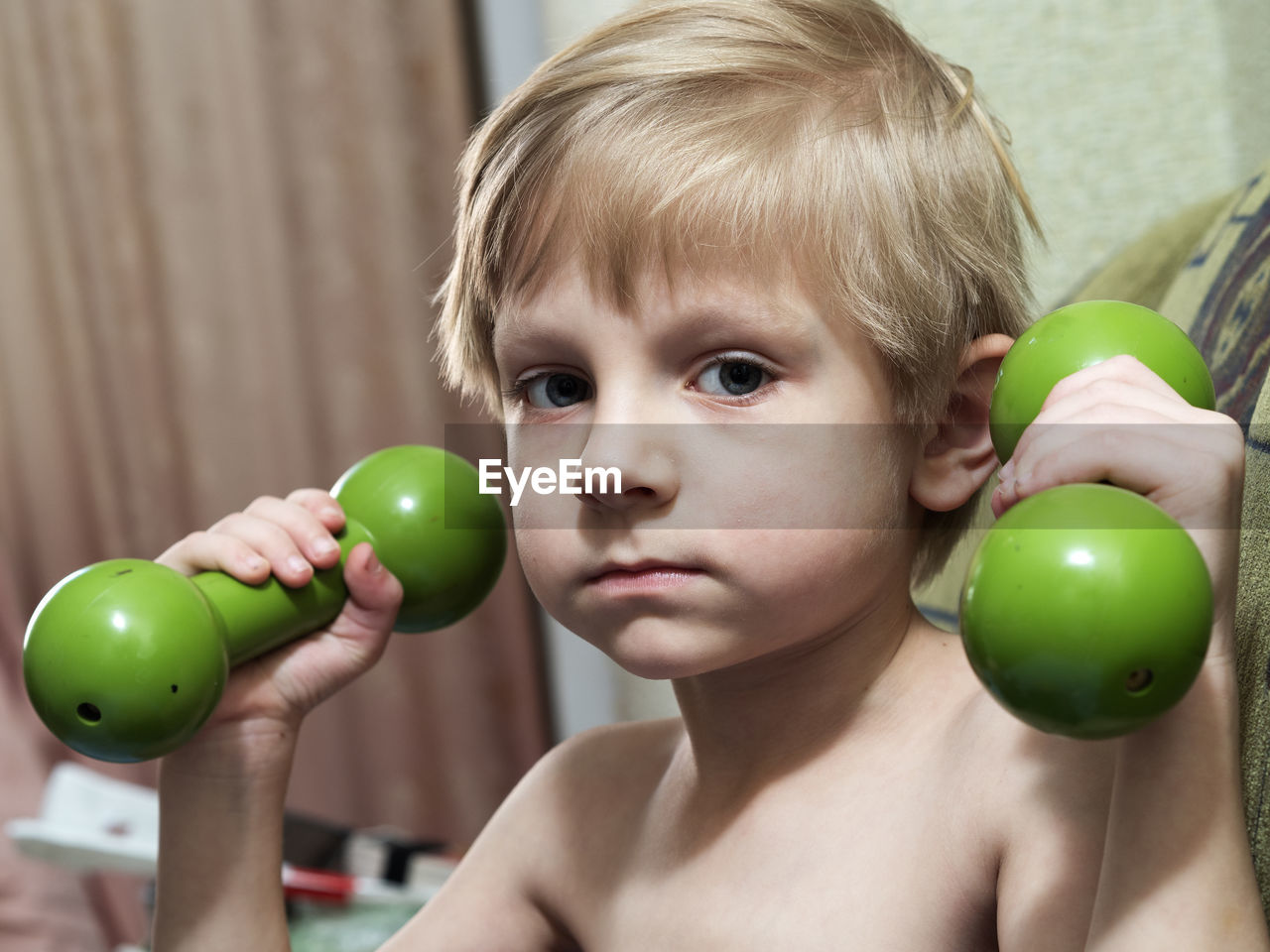 Portrait of boy holding dumbbell