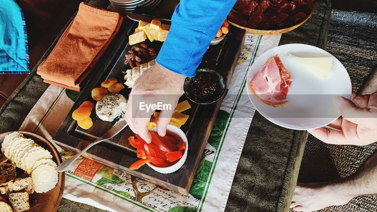 food and drink, food, high angle view, table, adult, freshness, meal, women, hand, lifestyles, healthy eating, fast food, drink, plate, two people, leisure activity, wellbeing, men, refreshment, eating, clothing, day, outdoors, holding, directly above, low section, business