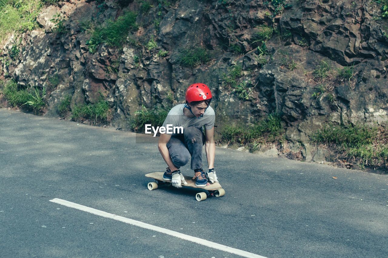Teenage boy skateboarding on road
