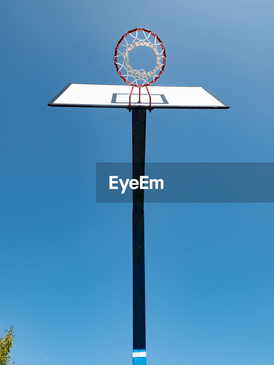 Outdoor basketball hoop in the park, blue sky background