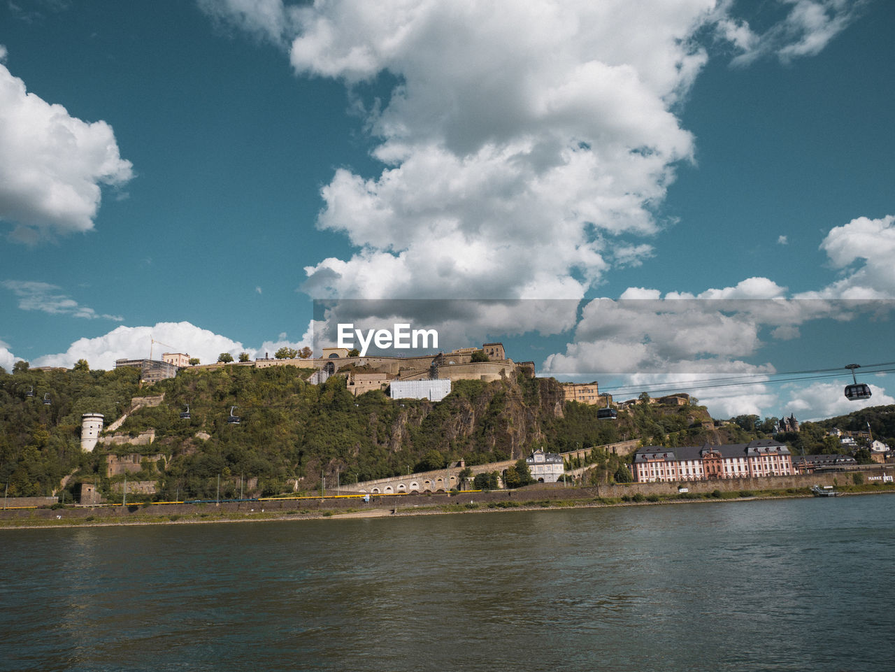 Scenic view of sea by buildings against sky