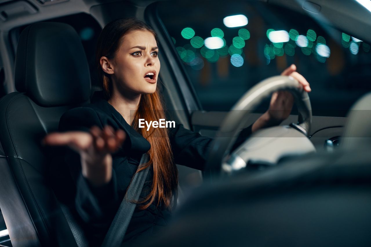 Irritated young woman driving car