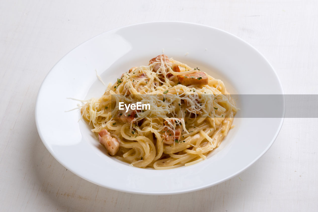 Close-up of spaghetti with carbonara in plate on table