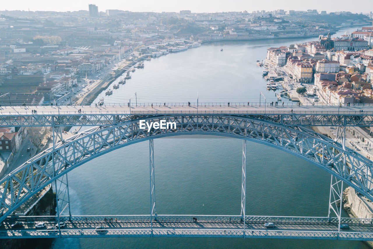 Aerial view of arch bridge over river in city