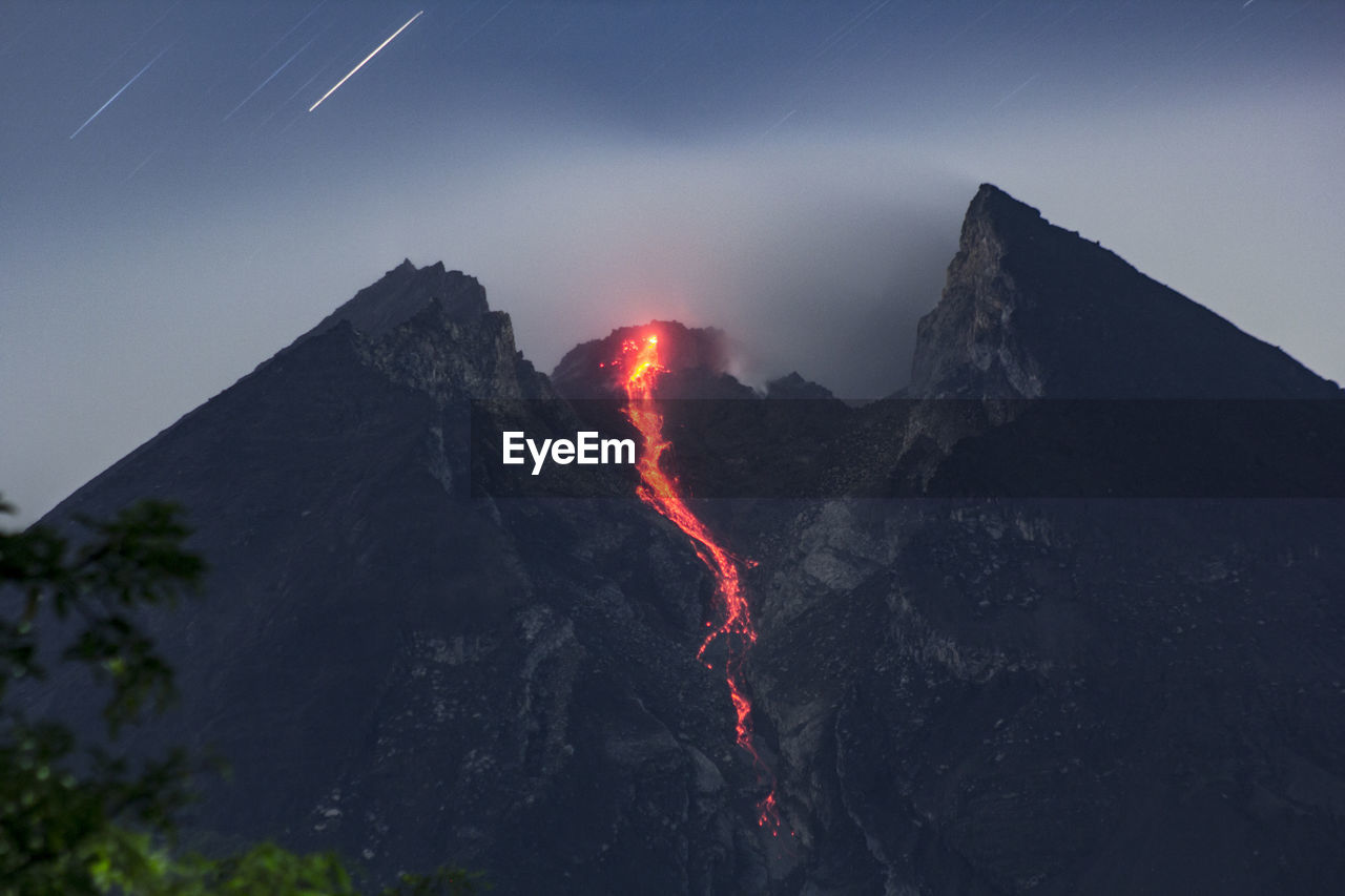 Volcanic erupting on mountain against sky