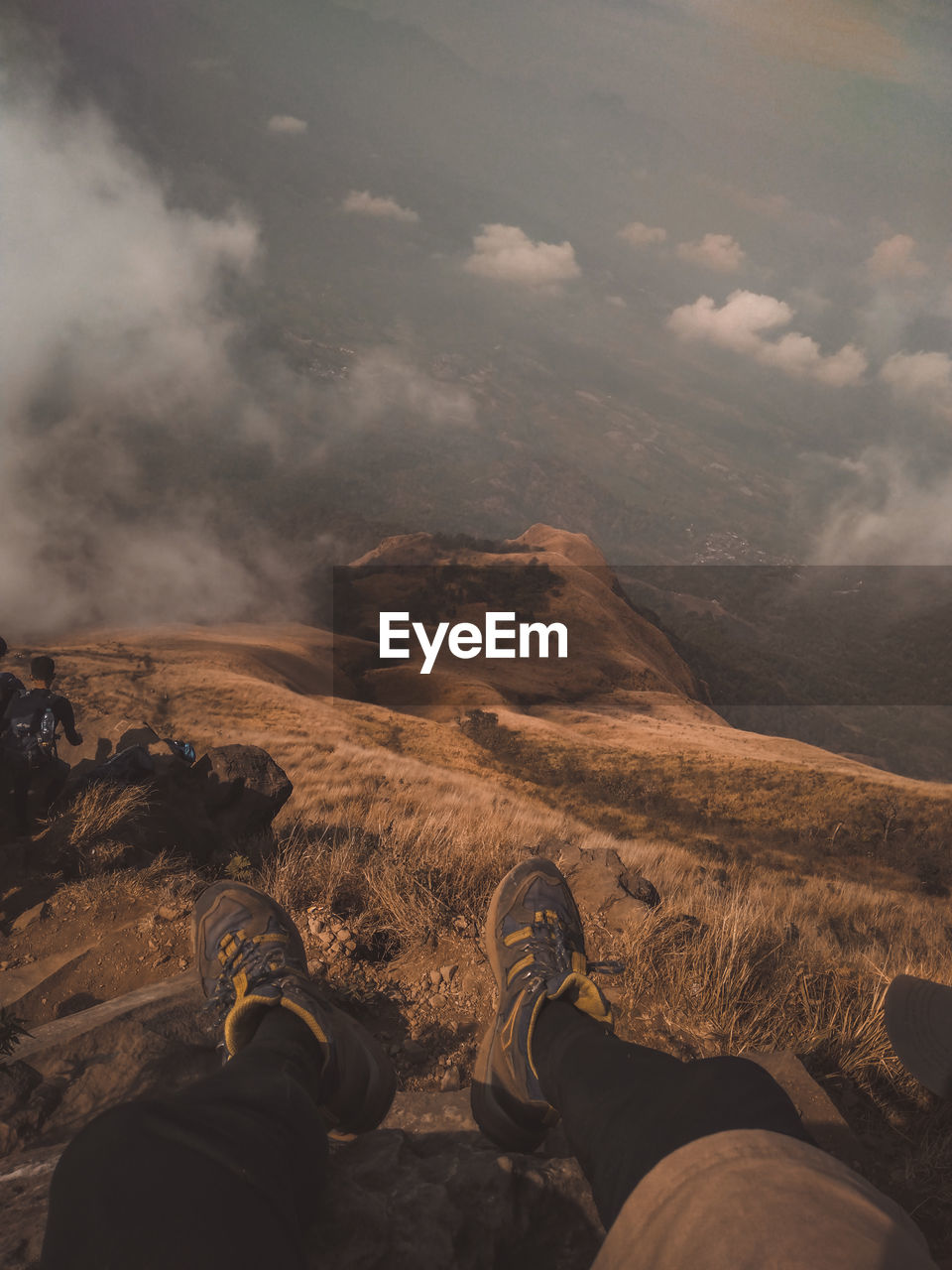 Low section of person on mountain against sky