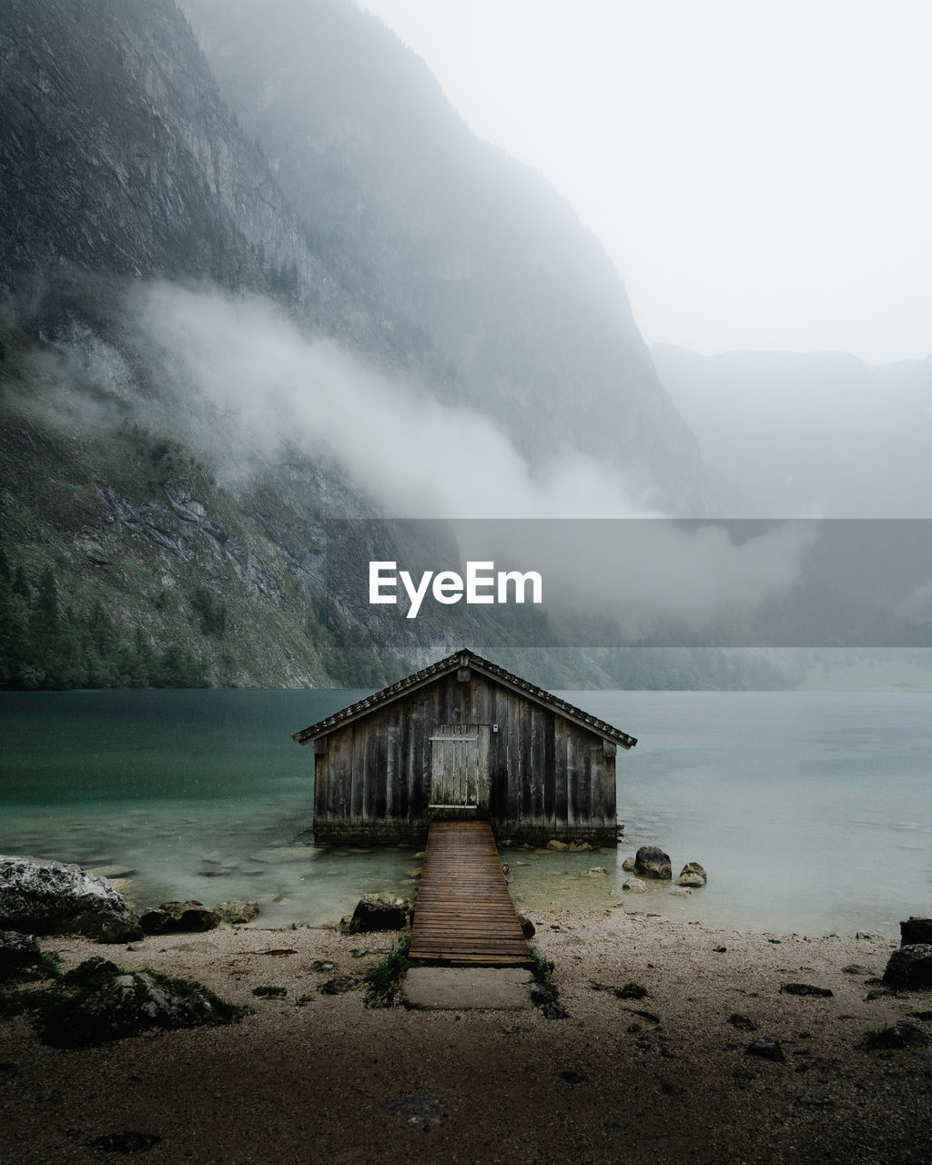 Scenic view of hut in lake against sky