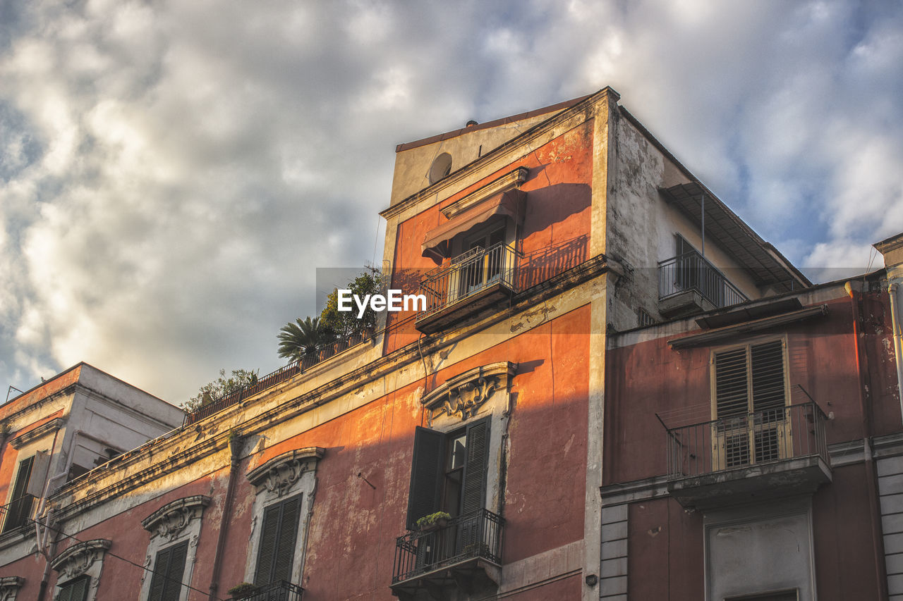 LOW ANGLE VIEW OF BUILDING AGAINST CLOUDY SKY