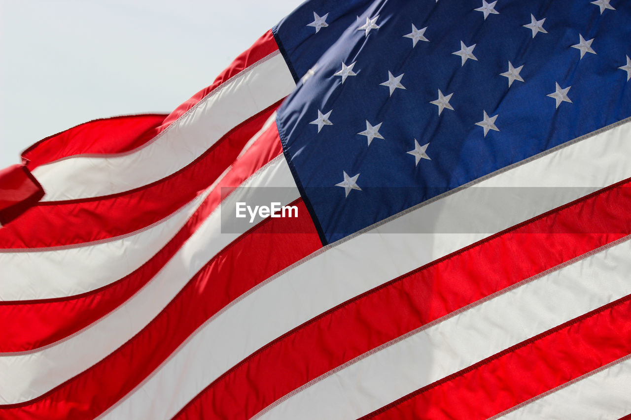 Close-up of american flag against sky