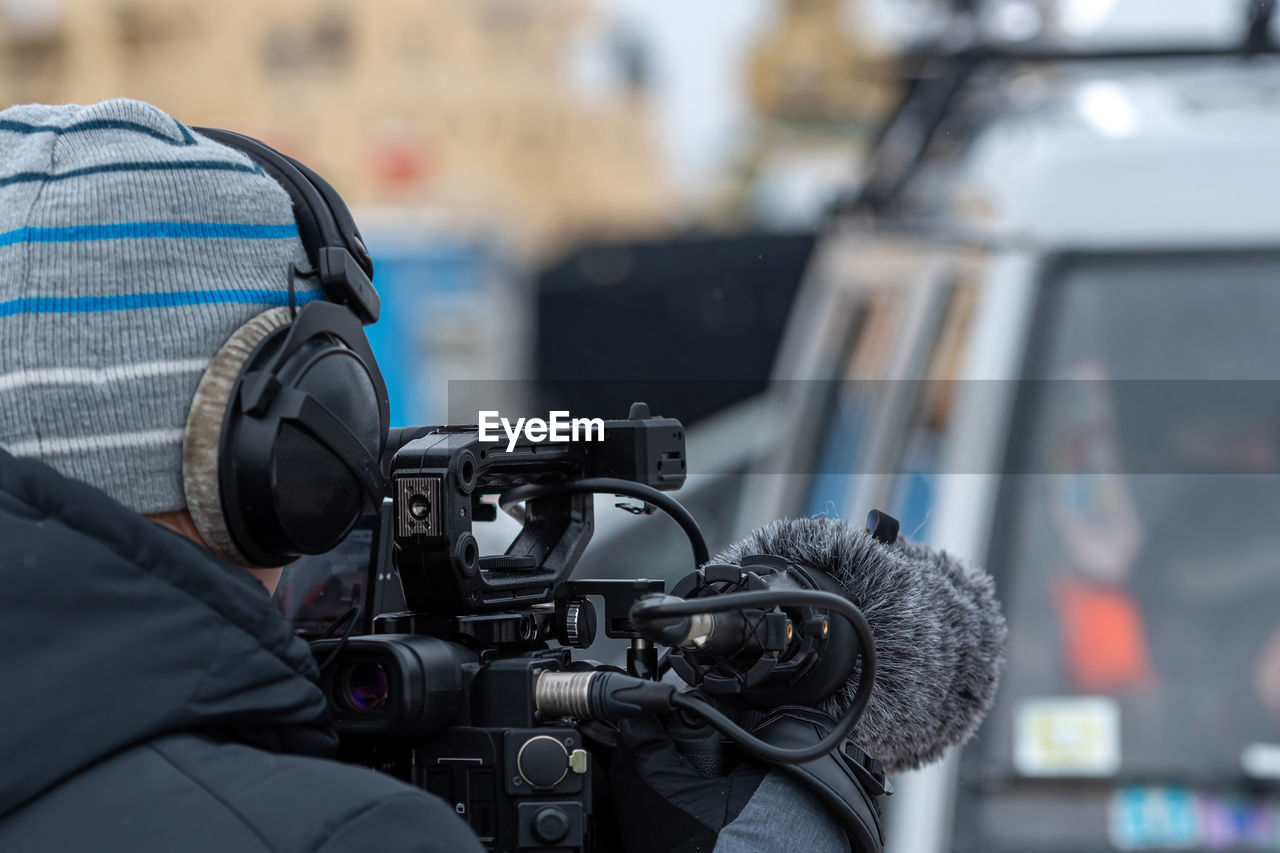 Rear view of man holding video camera