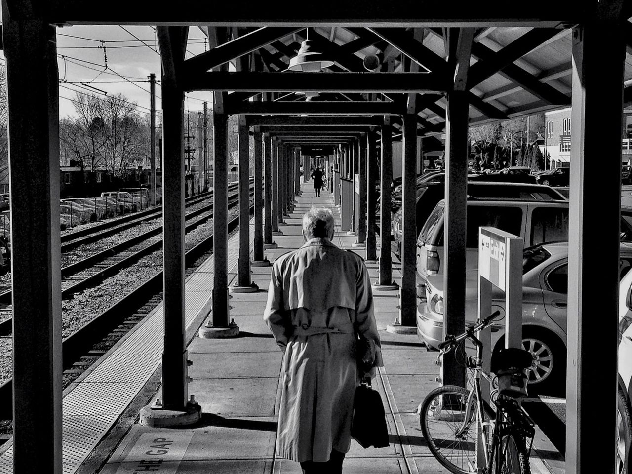 Rear view of man walking on railroad station platform