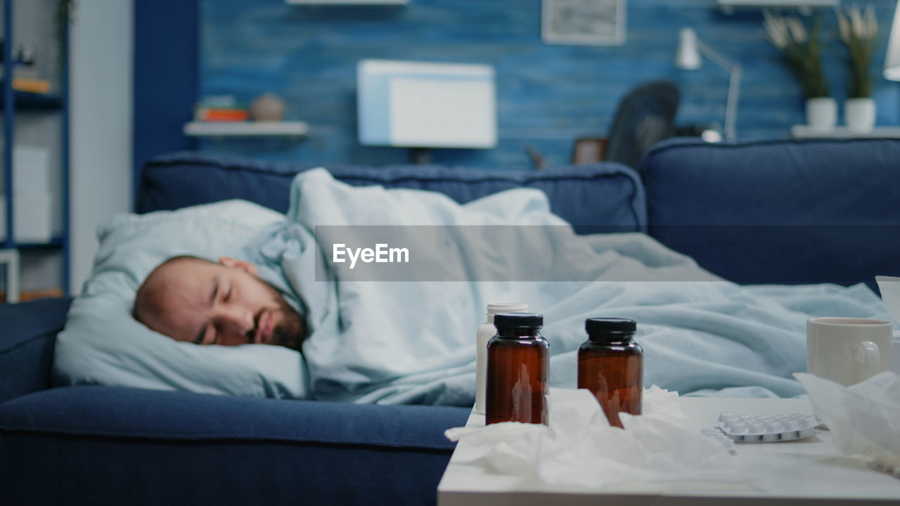 Sick man resting on sofa at home