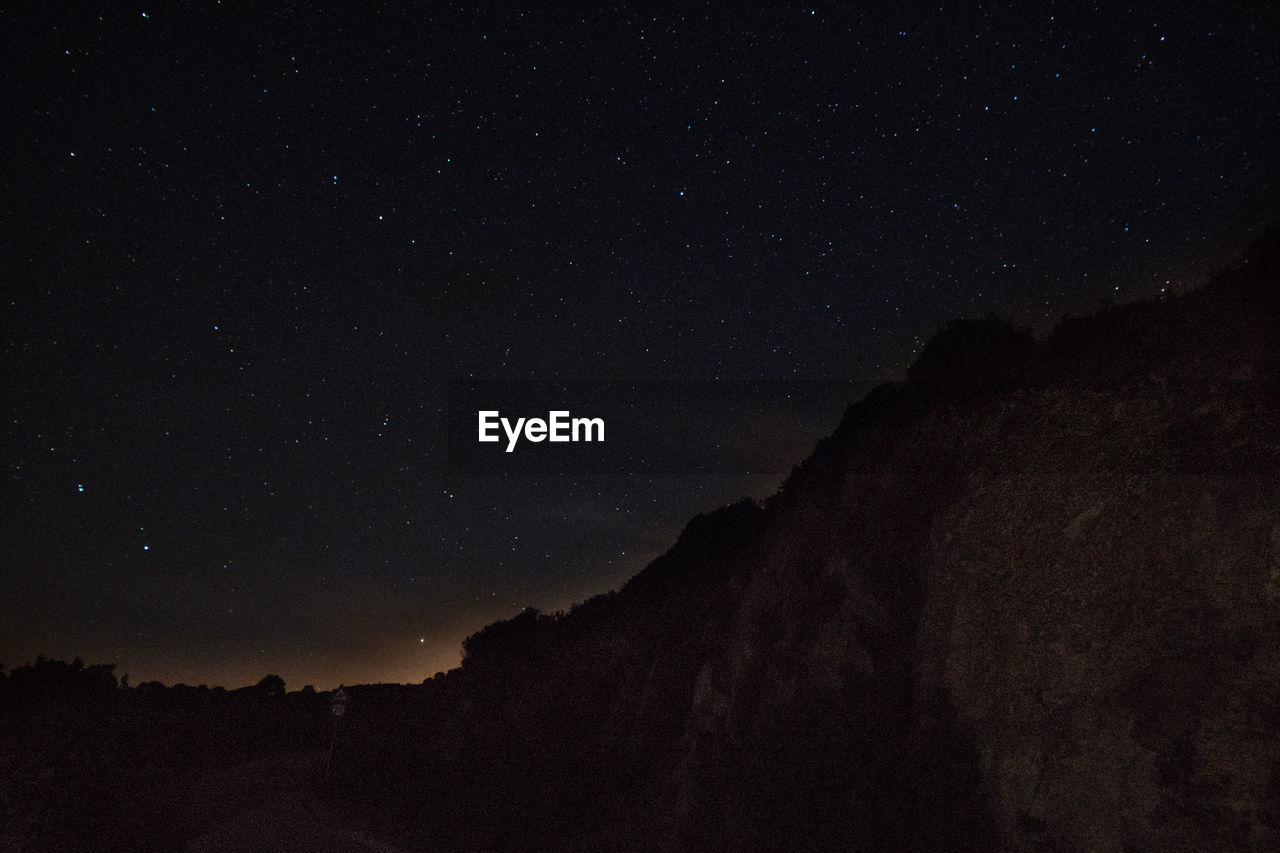 Low angle view of sunlight falling on mountain at night