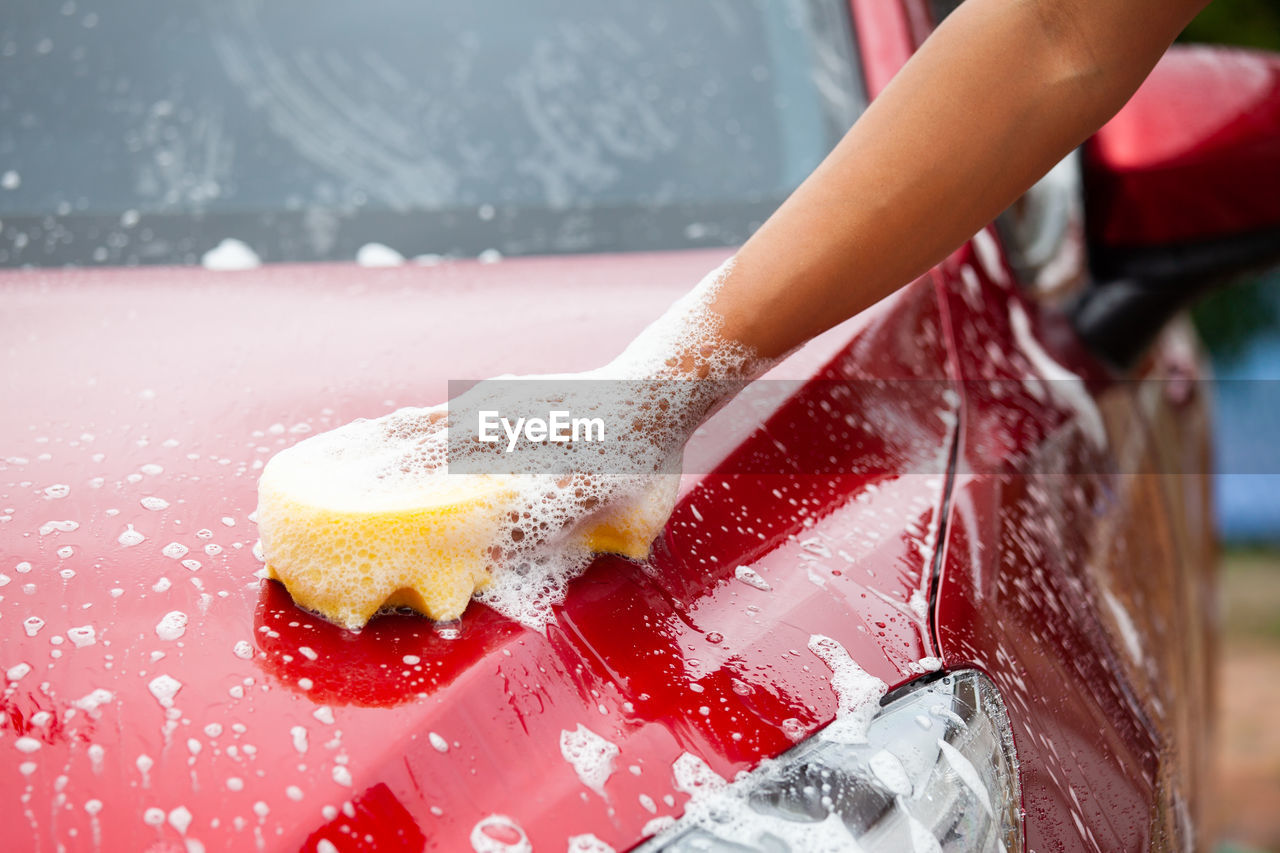 Cropped image of hand washing car