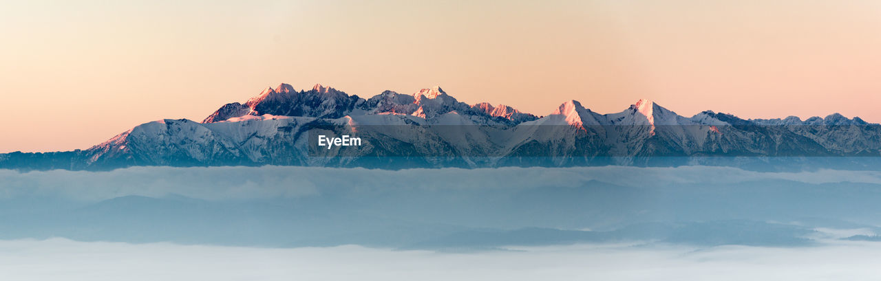 Scenic view of snowcapped mountains against sky during sunset