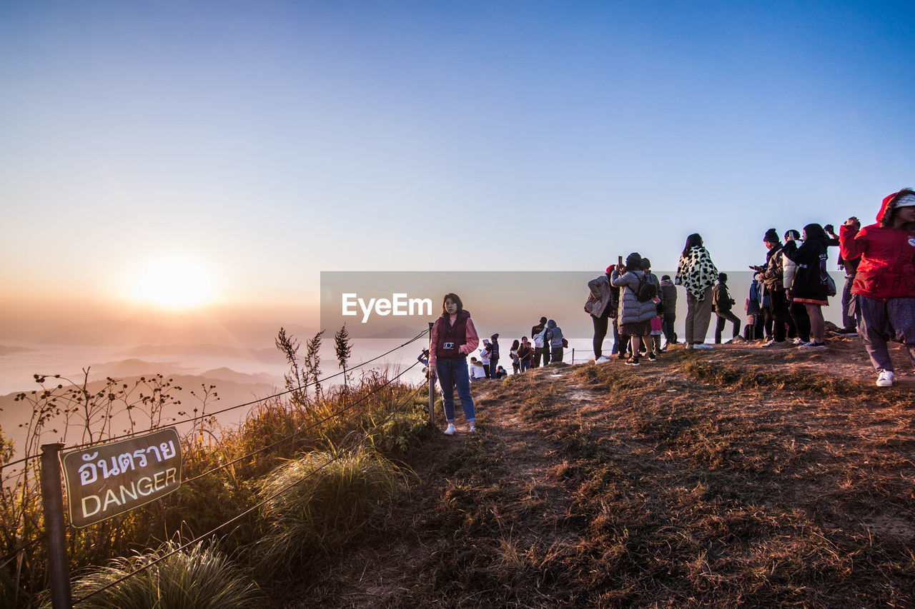 GROUP OF PEOPLE AGAINST CLEAR SKY AT SUNSET