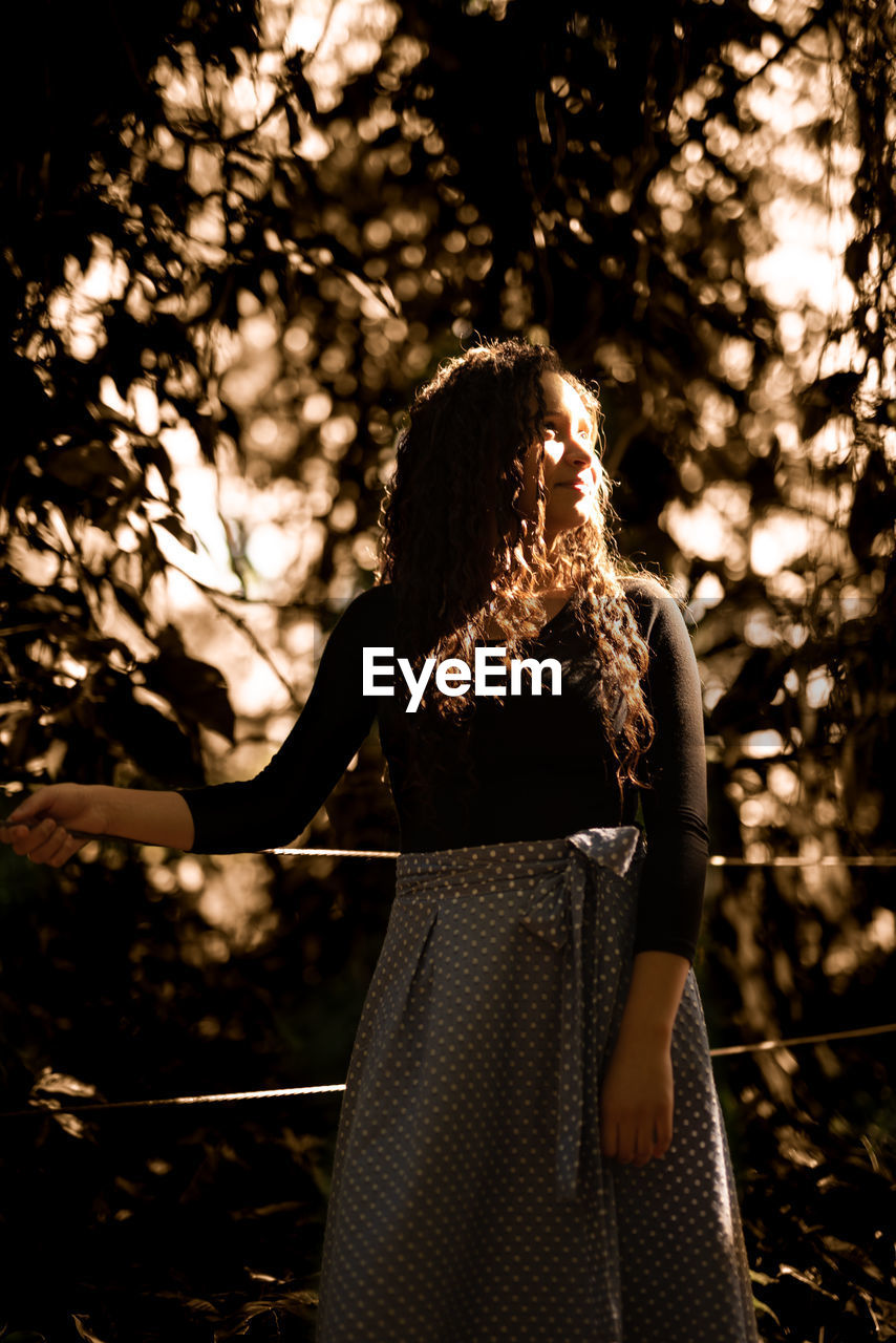 Woman standing against trees