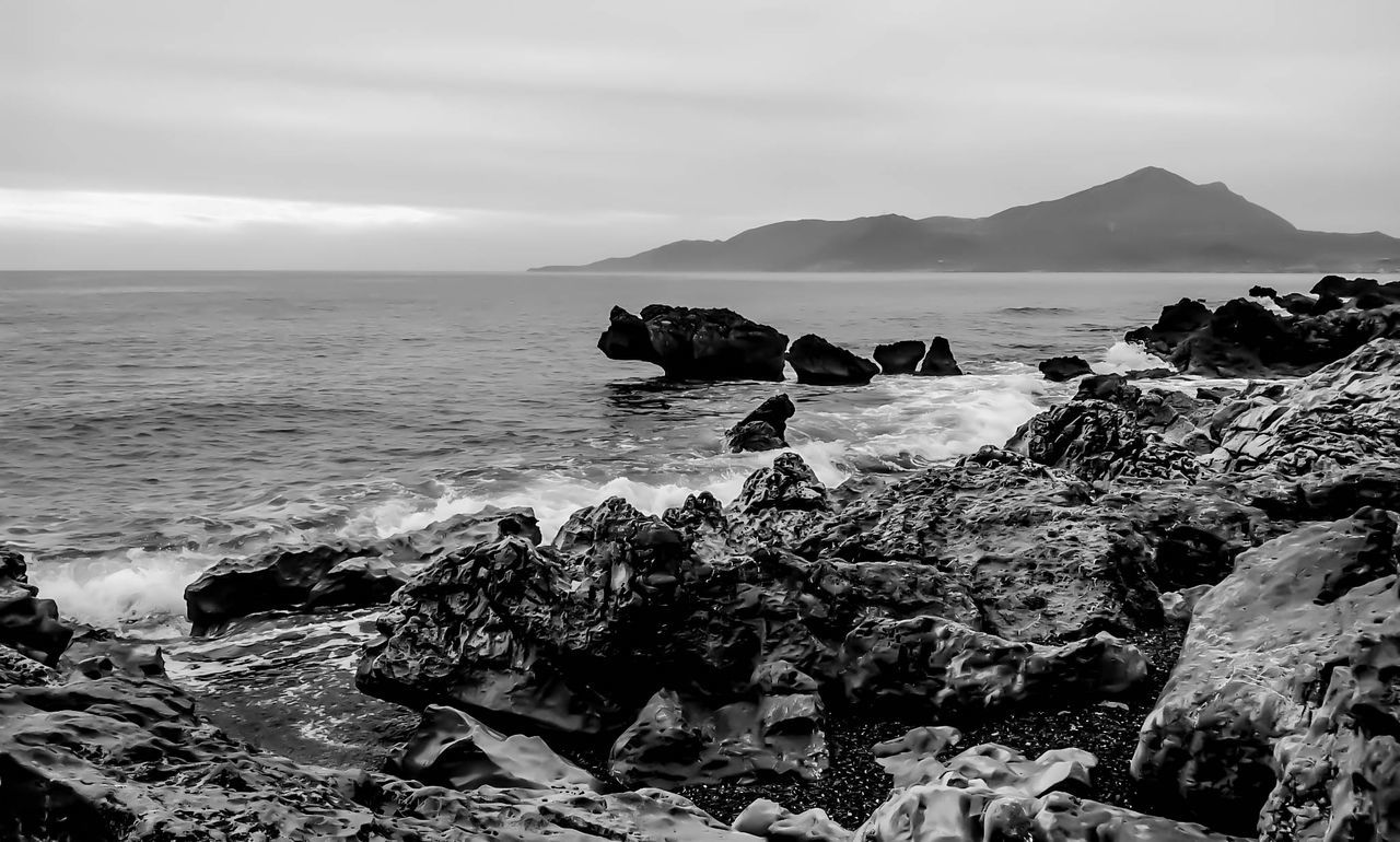 SCENIC VIEW OF SEA WITH ROCKS IN BACKGROUND