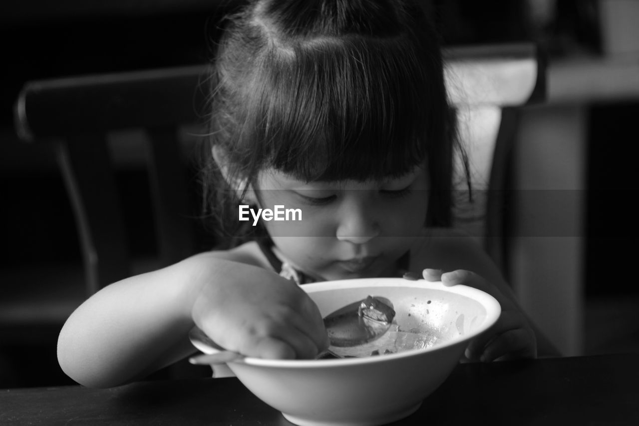 Girl by food in bowl on table