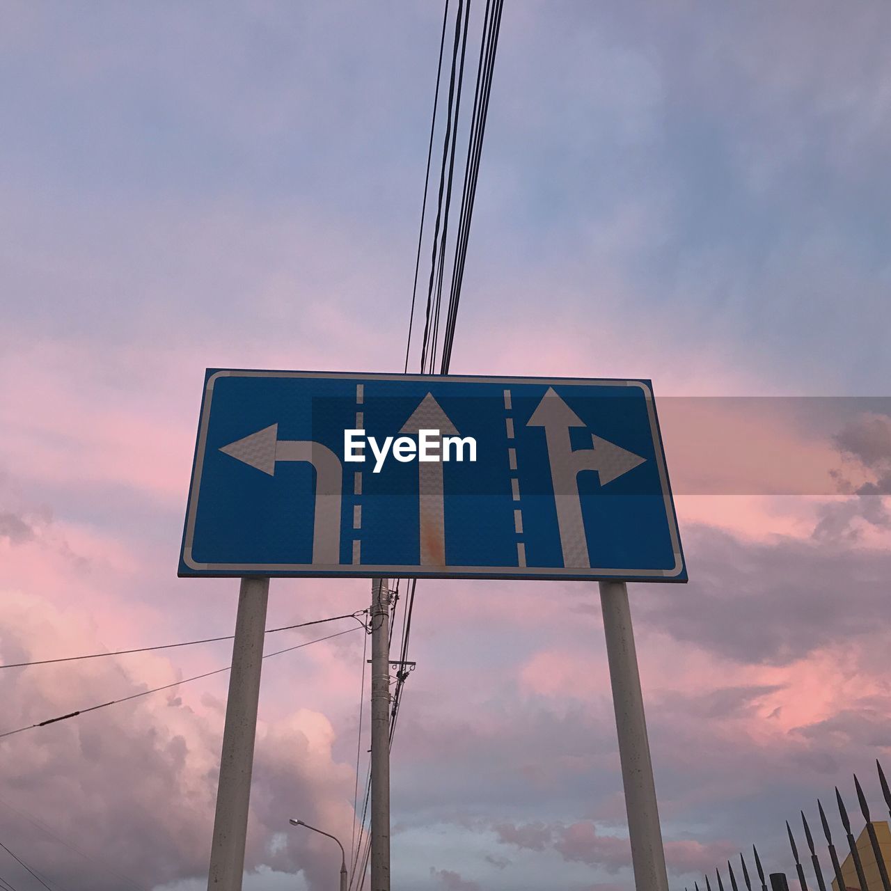 LOW ANGLE VIEW OF ROAD SIGN AGAINST SKY AT SUNSET