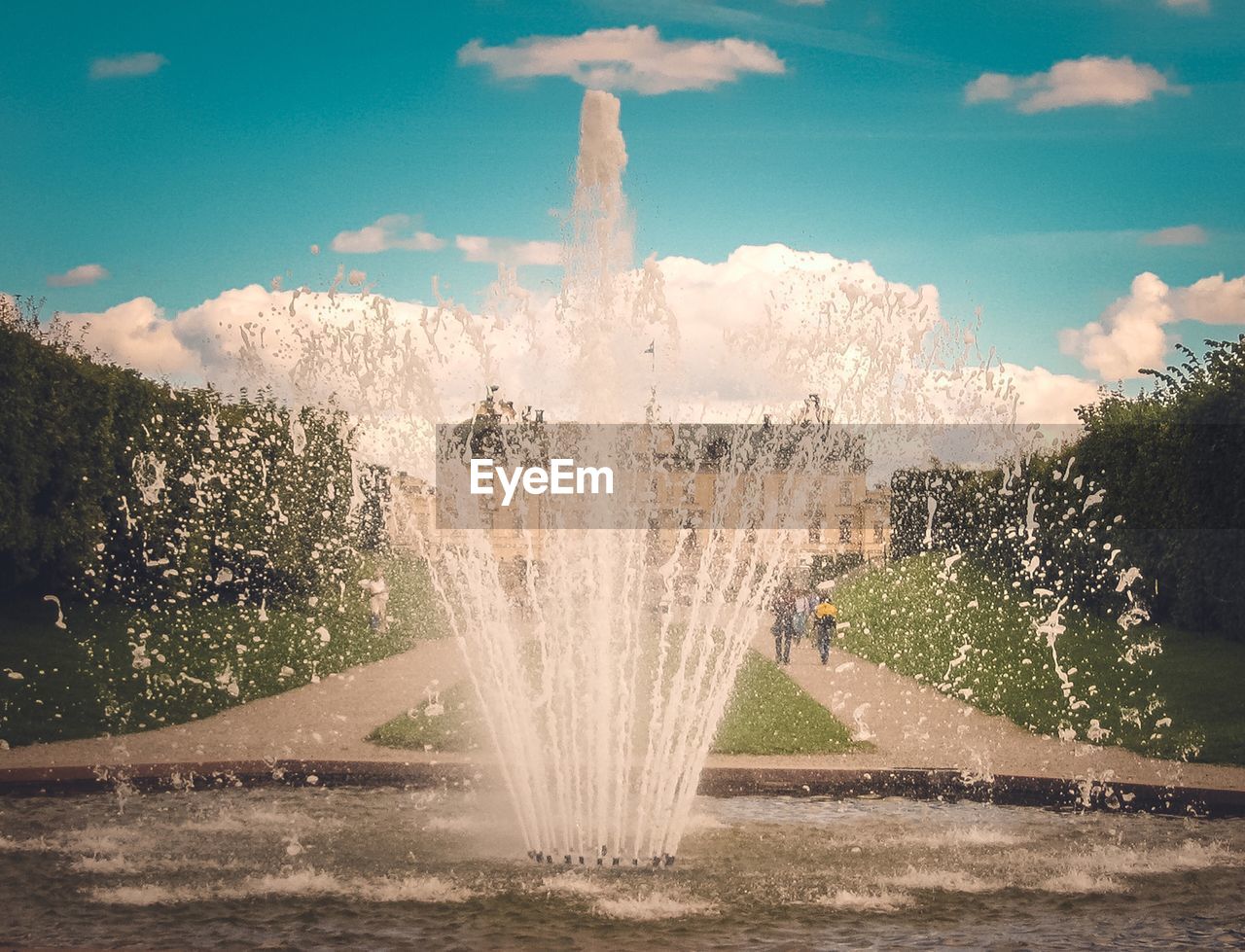 WATER SPLASHING ON FOUNTAIN AGAINST TREES