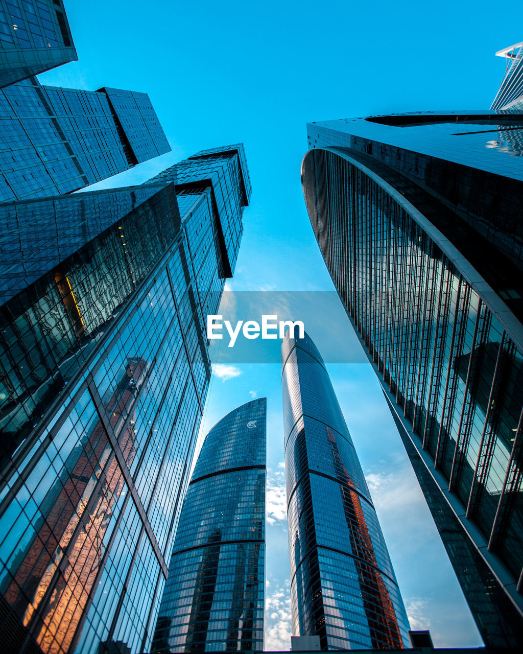 Low angle view of modern buildings against blue sky