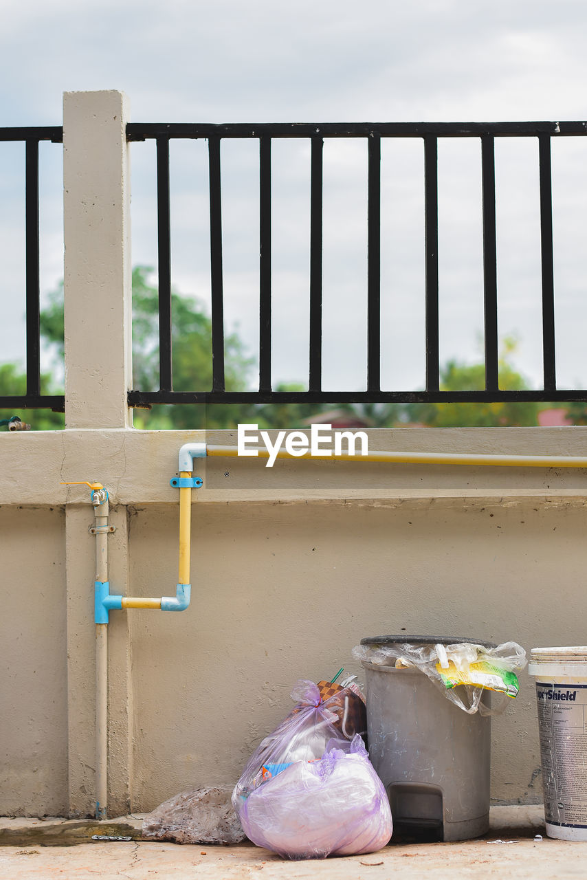 Garbage bin by window on wall