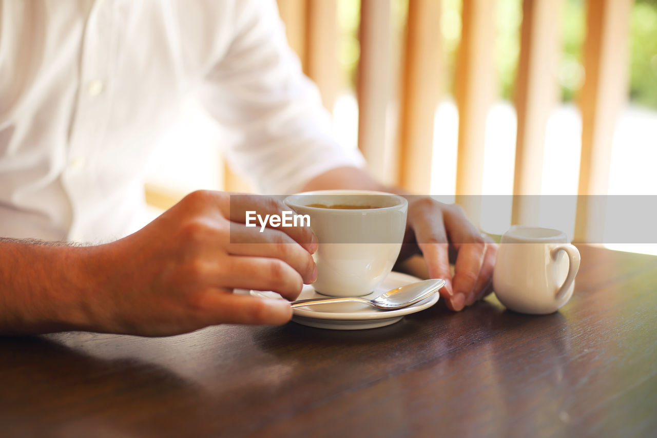 Midsection of coffee cup on table