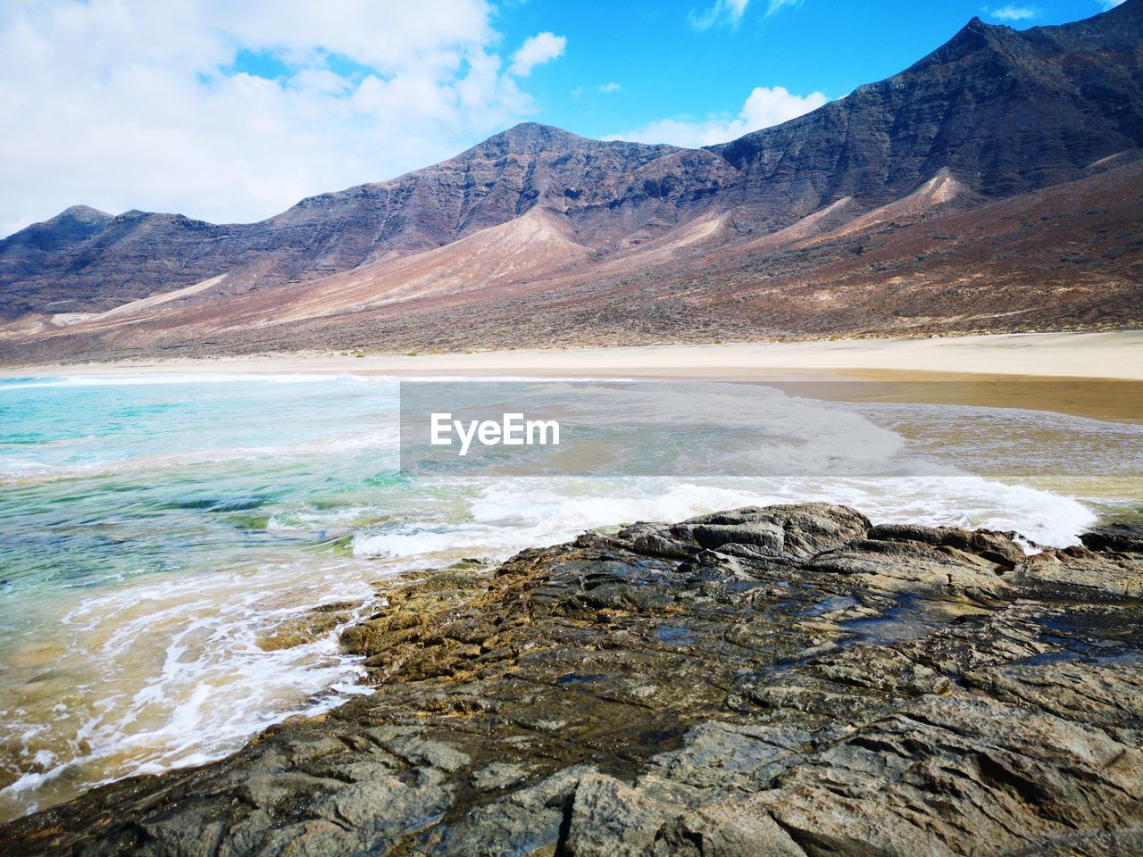 Scenic view of lake and mountains against sky