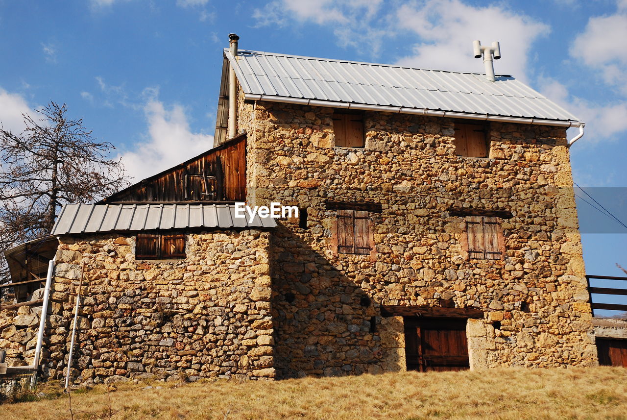 LOW ANGLE VIEW OF OLD HOUSE AGAINST SKY