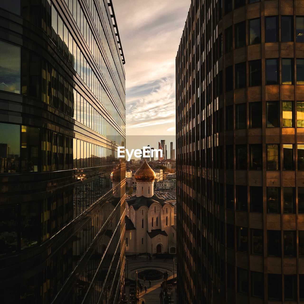 Buildings in city against sky at sunset