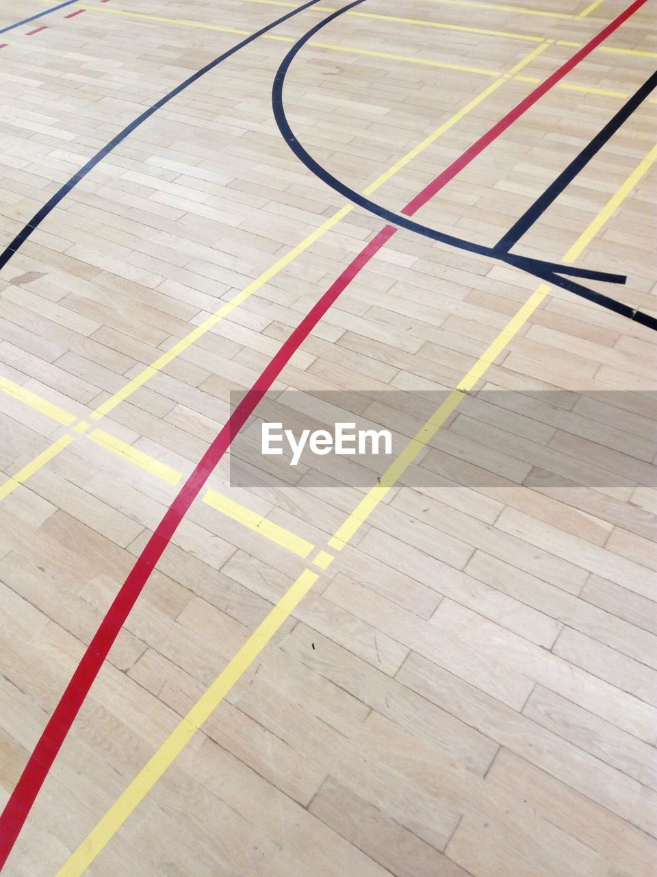 CLOSE-UP OF YELLOW BASKETBALL COURT IN HARDWOOD FLOOR