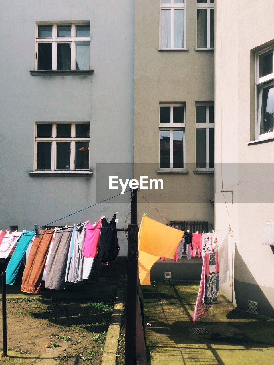 Fabrics drying on clotheslines outside building