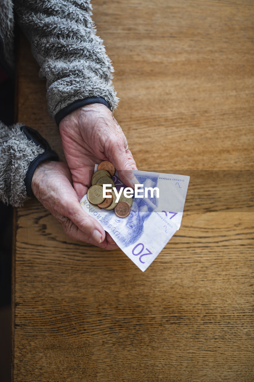 Hands holding banknotes and coins