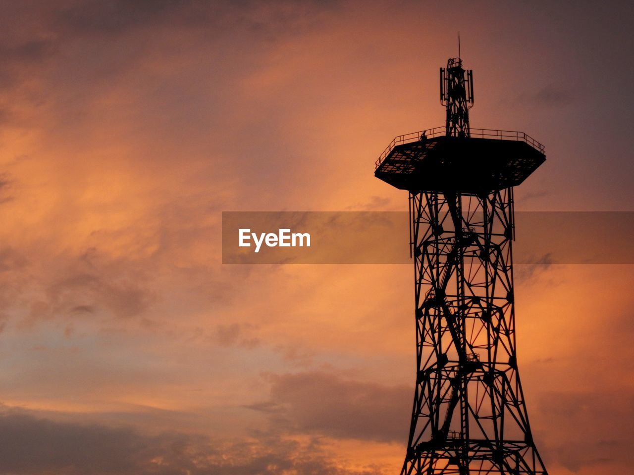 low angle view of electricity pylon against orange sky