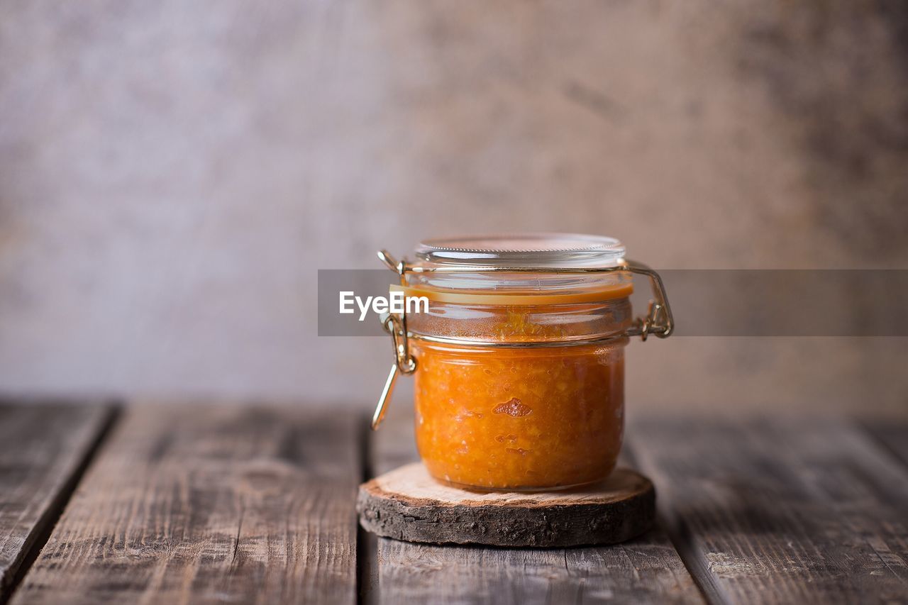 Marmalade in jar on table at home