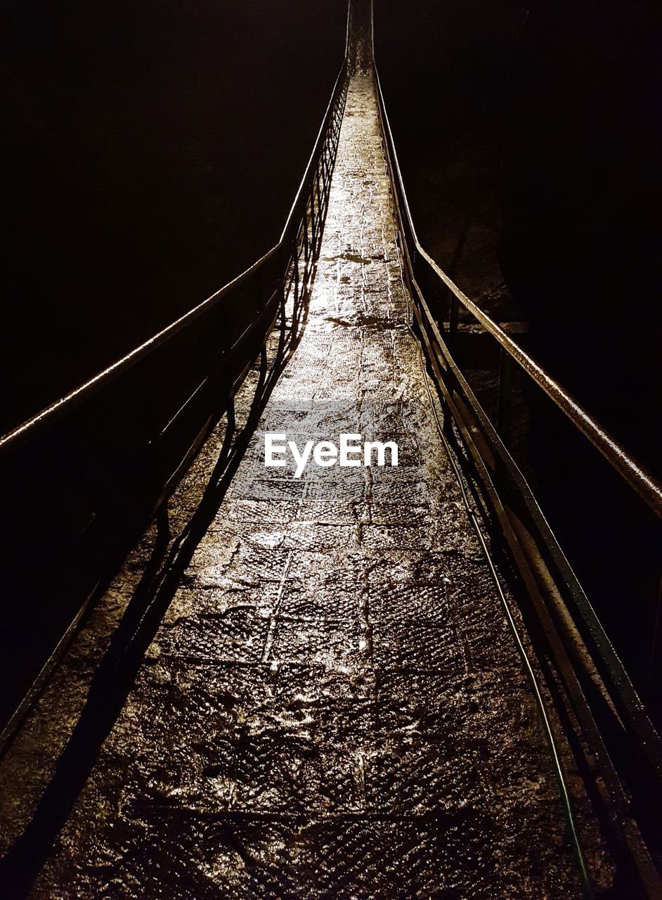 LOW ANGLE VIEW OF ILLUMINATED ELECTRICITY PYLON AGAINST SKY AT NIGHT