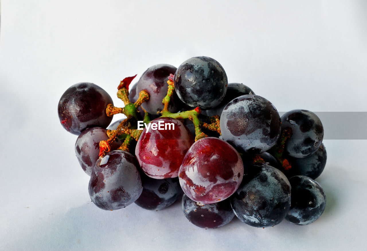 CLOSE-UP OF GRAPES ON WHITE TABLE