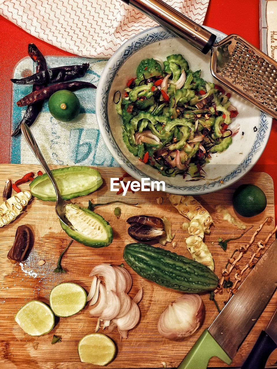 Directly above shot of bitter gourds and lemon on cutting board at table