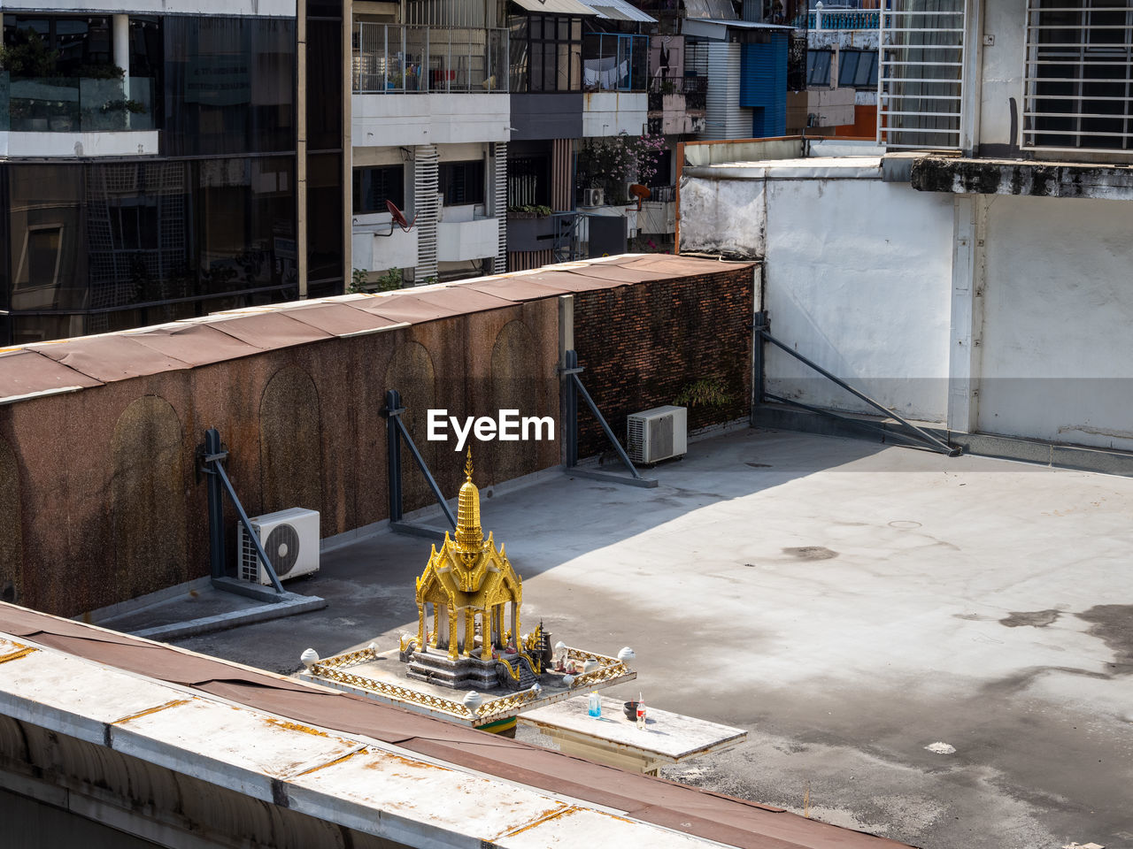 Local scene of a small golden buddhist temple on a rooftop in bangkok, thailand.